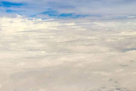 从空中俯瞰美丽的云景。 从天空和云层上方看自然之美。 从飞机窗口看到白云和蓝天。 天空中的阳光照耀着云层。