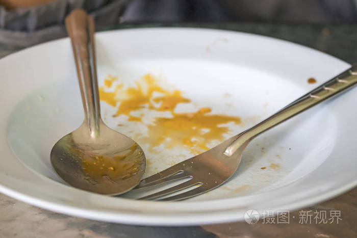 桌子上有勺子的脏盘子