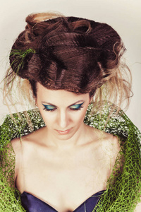 美丽的时装模特大发型在绿色网格和蓝色的连衣裙。长长的蓝色指甲的女人