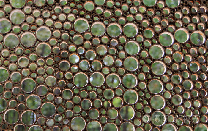 在旧格子的绿叶背景上的圆孔