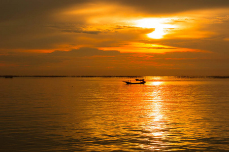 日落时的海上黄昏太阳。 红色的阳光大海和船