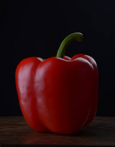 红柿子椒黑暗木制的桌子上一个黑色的背景上