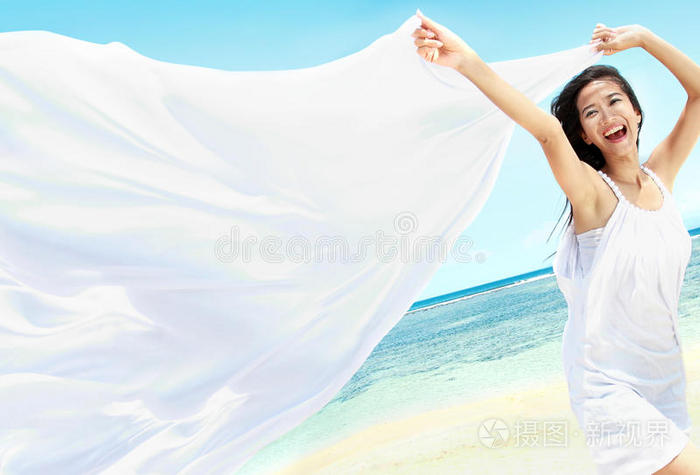 海滩上戴着白围巾的漂亮女孩