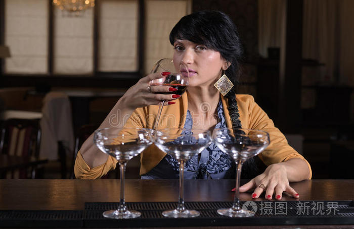 一个年轻女子独自在酒吧喝酒