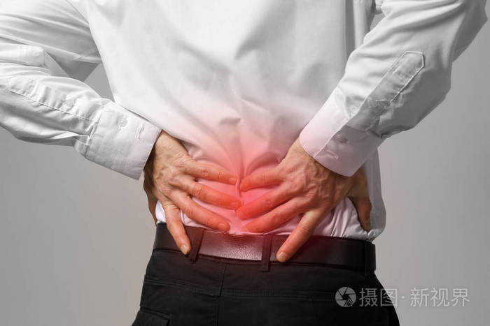 男子患有灰色的背景上背部疼痛.卫生保健概念