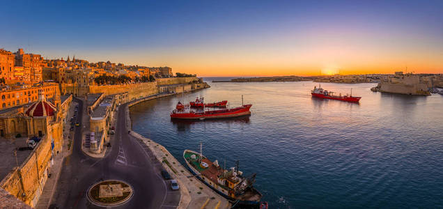 瓦莱塔，马耳他令人惊奇的夏季日出在瓦莱塔的大港口与船舶和古民居的全景镜头和墙壁的马耳他首都