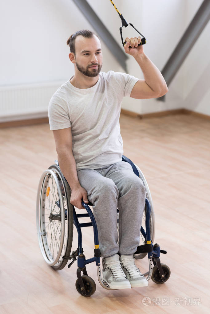 伸展的电缆在健身房里的魅力年轻残疾人