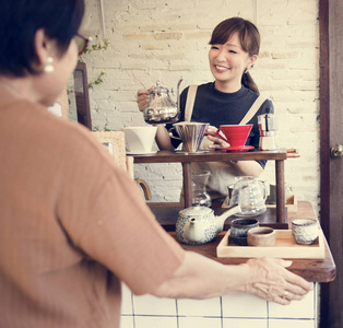 女服务员浇注茶在杯中