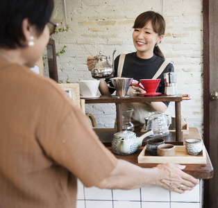 女服务员浇注茶在杯中