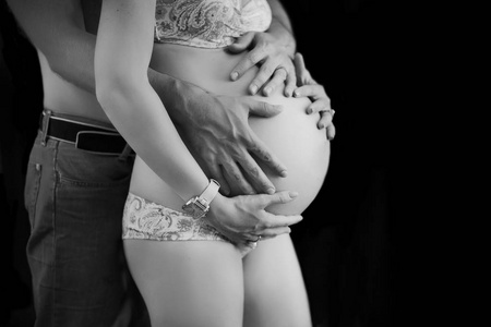 怀孕夫妇拥抱，黑白照片，不露面的肖像