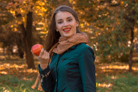 快乐的女孩在公园保持苹果在手