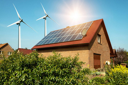 房子和风的汽轮机周围可持续资源的概念屋顶上的太阳能电池板
