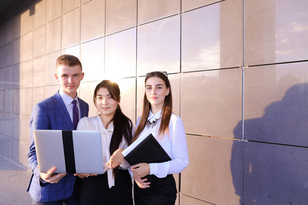 三个美丽的年轻人 学生，两个女孩和男孩举行我