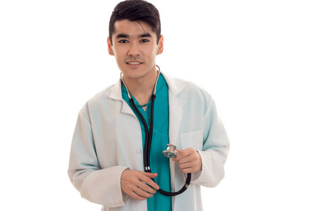 快乐年轻男医生穿着制服，在 stathoscope 摆姿势孤立在白色背景上