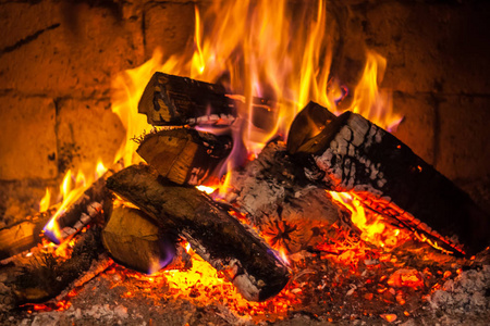 壁炉里的火苗,冬天的黑红色圣诞树上的装饰品和背景壁炉里的火壁炉里