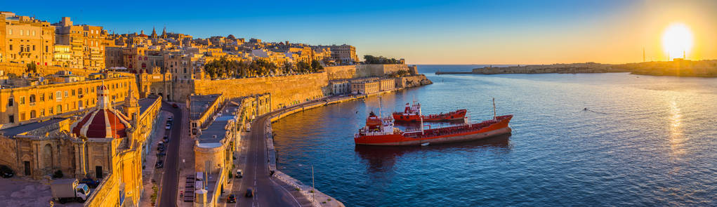 瓦莱塔，马耳他全景的天际线景观的瓦莱塔和大港口中，美丽的日出 船只和清澈的蓝天