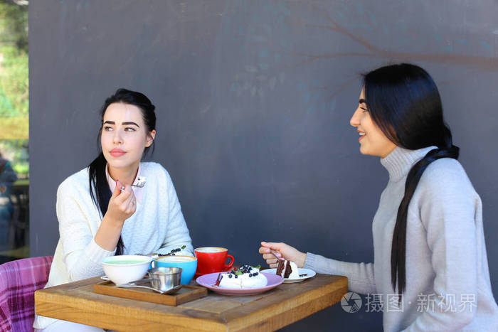 三个美丽的女人的微笑在咖啡馆,说话,告诉秘密, 吃饭,d