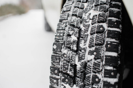 汽车轮胎的冬季的特写镜头。在深秋的第一场雪