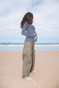 怀孕在海滩手在肚子上