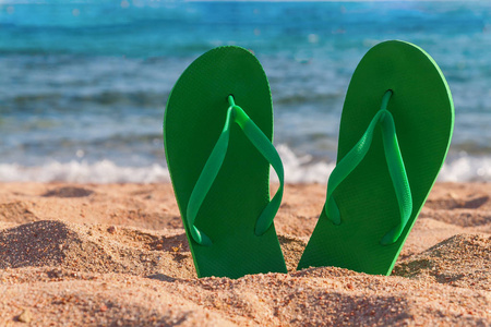 绿色在海边沙滩拖鞋照片