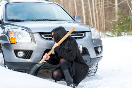 年轻漂亮的女人铲和从她的车除雪