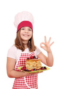 快乐的小女孩用煎饼和 ok 手势做饭