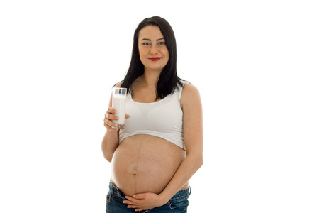 漂亮的年轻孕妇黑发女人接触隔离在白色背景上她的肚子和饮料牛奶