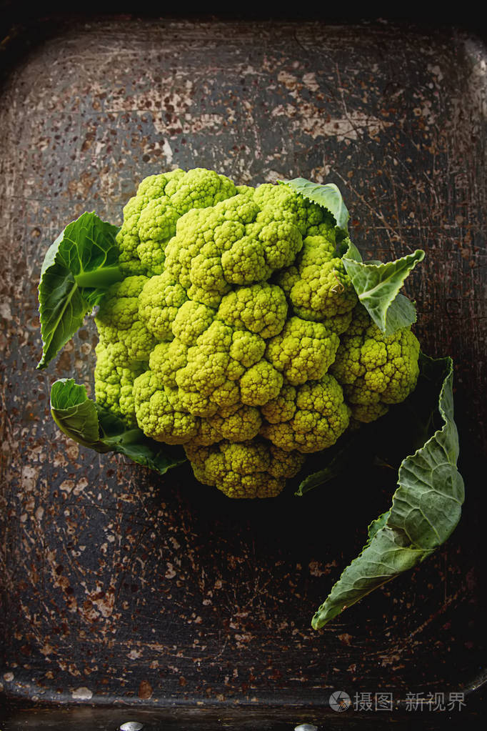 成熟的绿菜花用树叶深色木背景