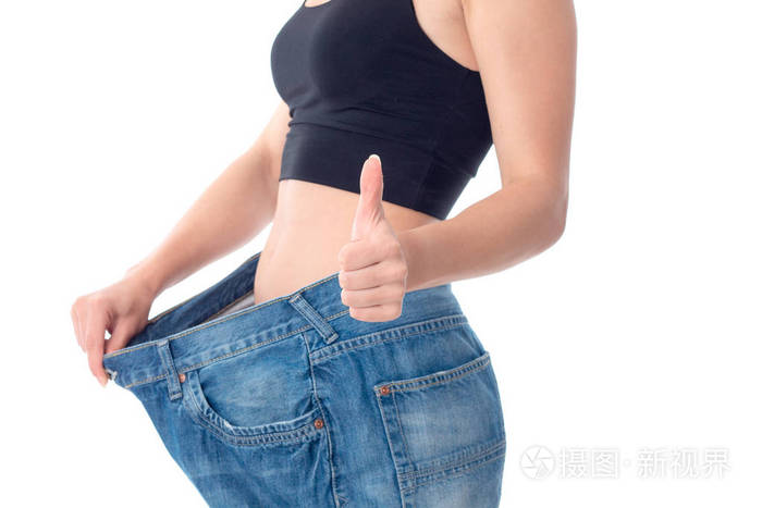 年轻苗条的女孩穿大宽裤和白色背景上显示的孤立类