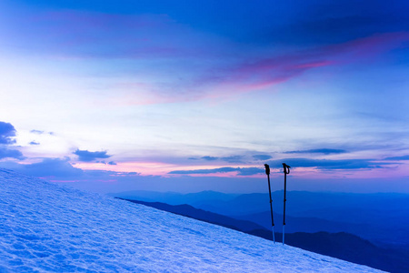 丰富多彩的冬季日出山。根滑雪杖或登山杆