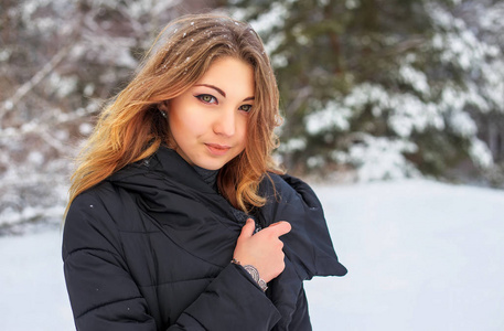 美丽微笑的少女在冬天冷雪林