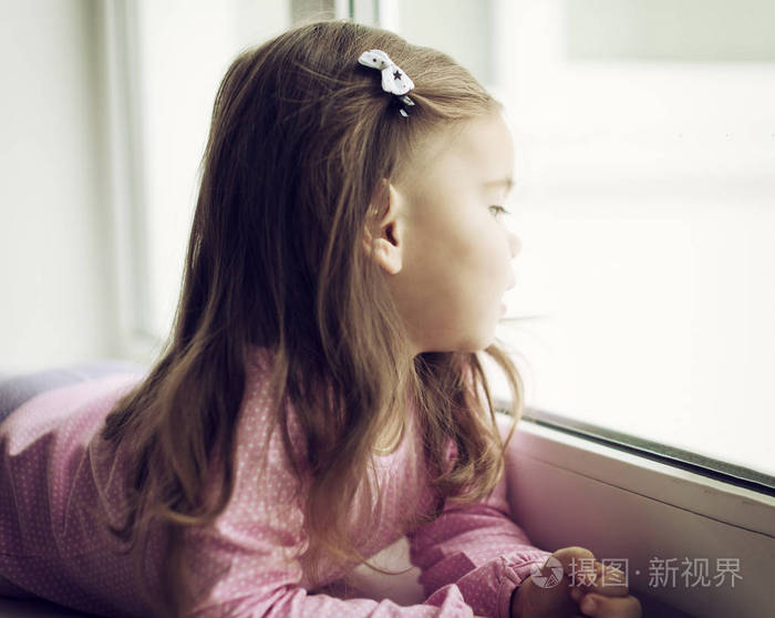可爱的小女孩趴在窗台上