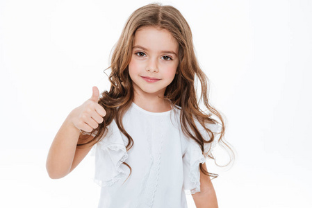 快乐可爱的小女孩站和显示竖起大拇指照片