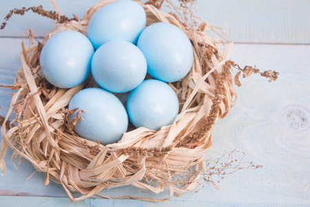 蓝色复活节彩蛋在巢的木制背景。
