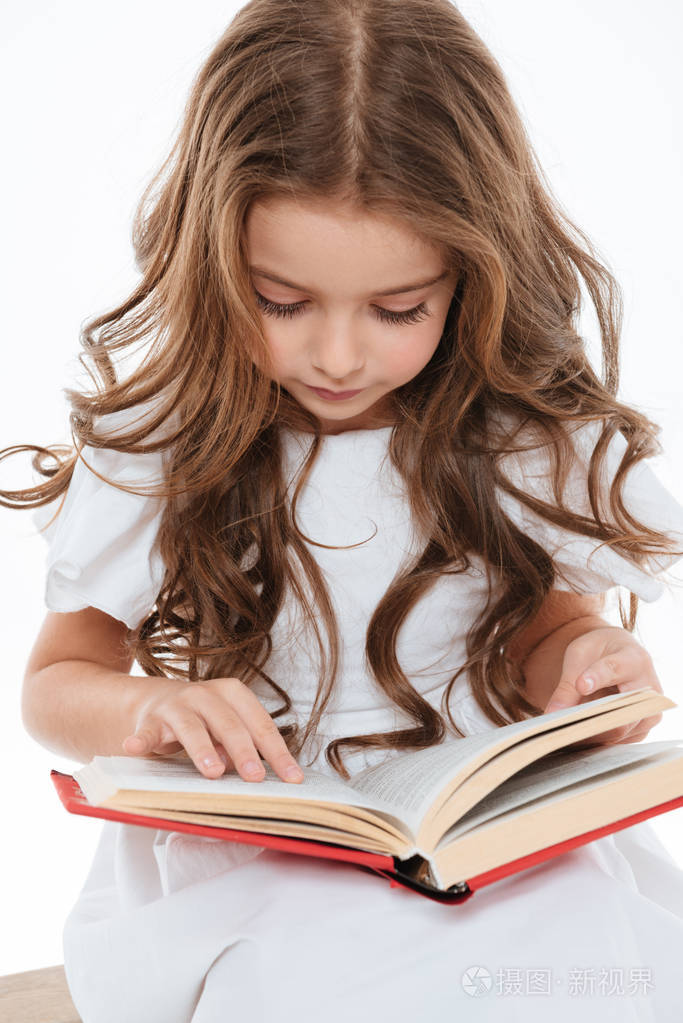 漂亮卷发的小女孩坐,读的书