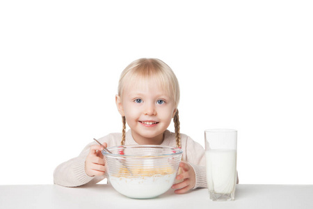 微笑的小女孩吃片。白色背景上孤立
