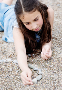 玩石头躺在鹅卵石上的女孩