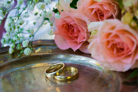 结婚戒指在颁奖典礼前的，与装饰的香槟杯和玫瑰