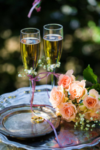 结婚戒指在颁奖典礼前的，与装饰的香槟杯和玫瑰