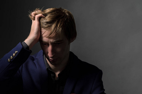 后面他的脸沮丧的拉丁男人坐在楼梯井里,双手抱头,感到孤独和悲伤,并