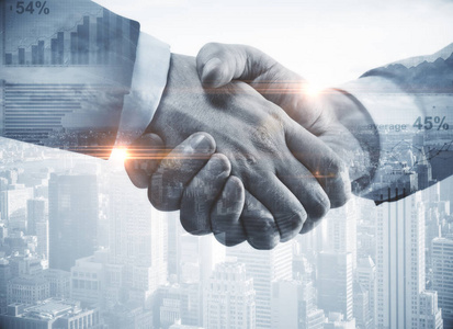 握手在抽象城市背景下的靠拢.团队合作的概念.二次曝光.