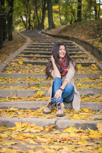 秋天公园里坐在石阶上的女孩