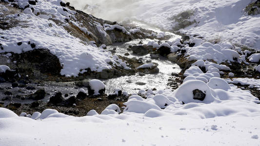 在雾中的登别温泉雪特写镜头的石头和溪水