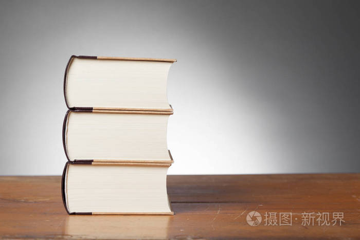在一张木桌上的三本书