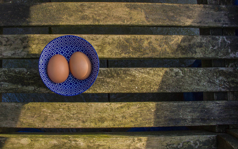 在一个美丽的蓝色碗用模式两个新鲜的鸡蛋