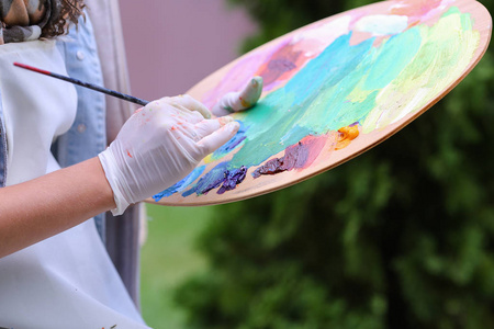 女性艺术家的手榨木苍白管油油漆