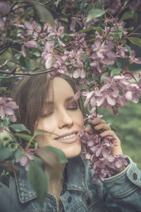 公园里的粉色绿树鲜花的年轻女人