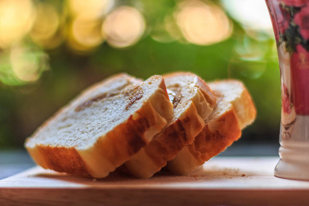切片的面包自制片面包上木盘子和杯子