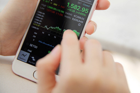 网上交易在智能手机与商务女人手上照片