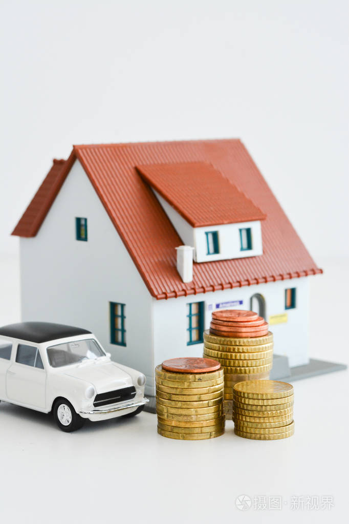 与叠硬币孤立在白色背景上的车子和房子模型